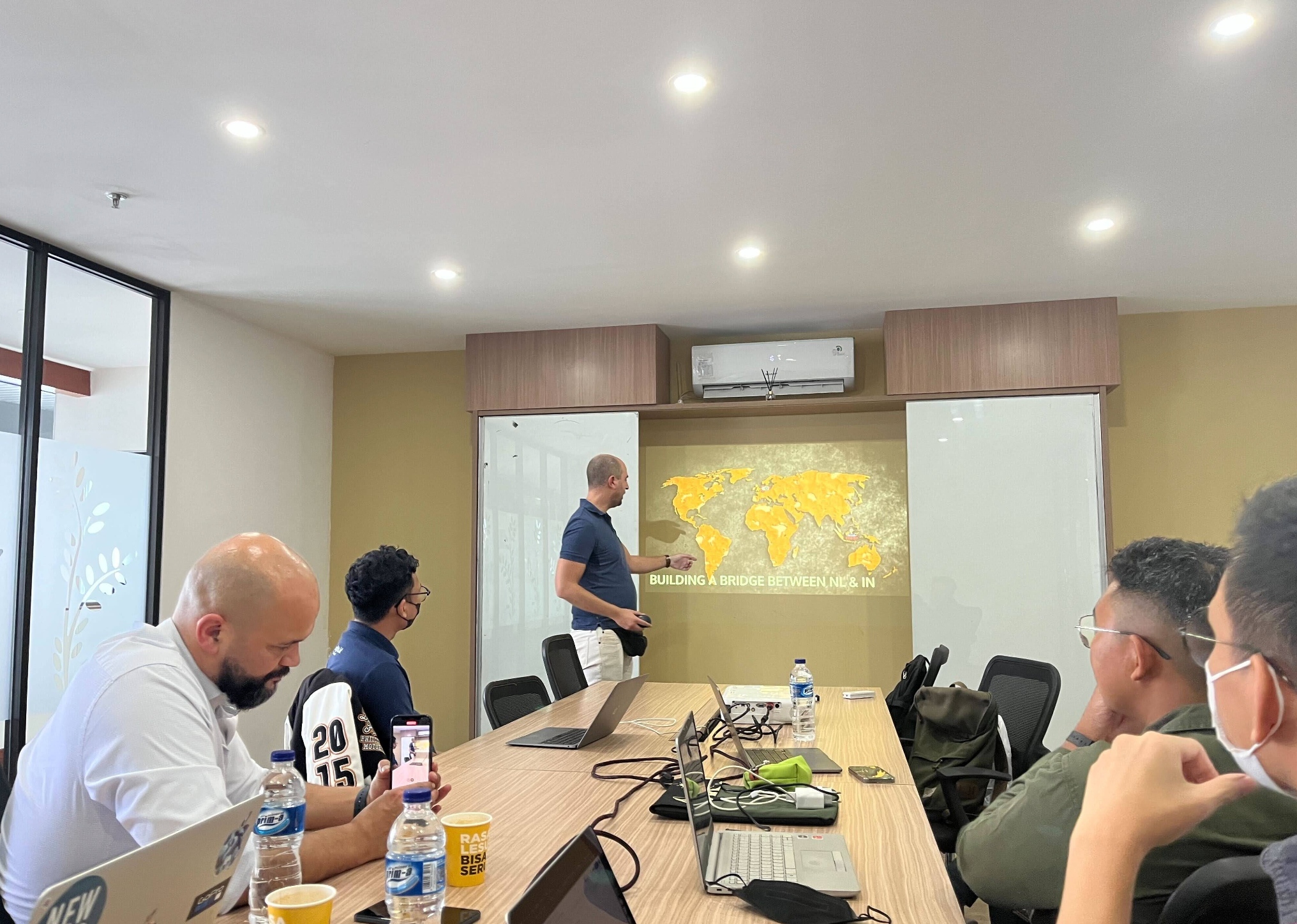 Professional business meeting in modern conference room with team members discussing global staffing solutions, showcasing Hitopia's collaborative approach
